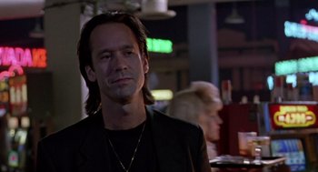 Movie still from “Leaving Las Vegas” (1995), directed by Mike Figgis – A man with long hair is sitting at a table; Close Up shot, Low angle