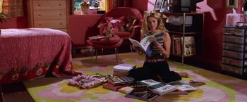 Movie still from “Legally Blonde” (2001), directed by Robert Luketic – A woman sitting on the ground reading a book; Wide shot, High angle