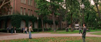 Movie still from “Legally Blonde” (2001), directed by Robert Luketic – A man standing on the side of a road next to a building; Extreme Wide shot, High angle