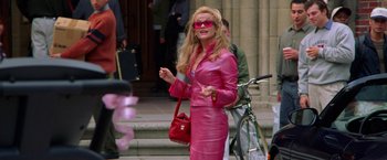Movie still from “Legally Blonde” (2001), directed by Robert Luketic – A woman in a pink suit and sunglasses; Wide shot, Low angle