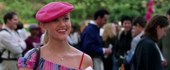 Movie still from “Legally Blonde” (2001), directed by Robert Luketic – A woman wearing a pink hat smiling for the camera; Medium shot, High angle