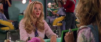 Movie still from “Legally Blonde” (2001), directed by Robert Luketic – A woman sitting in front of another woman in front of a mirror; Medium shot, Over the shoulder angle