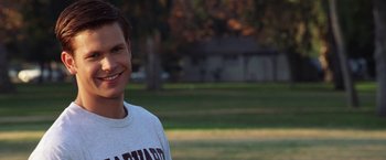 Movie still from “Legally Blonde” (2001), directed by Robert Luketic – A young man smiling for the camera in a park; Close Up shot, Over the shoulder angle
