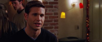 Movie still from “Legally Blonde” (2001), directed by Robert Luketic – A man in a black shirt is sitting in front of a brick wall; Close Up shot, Over the shoulder angle