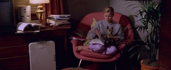 Movie still from “Legally Blonde” (2001), directed by Robert Luketic – A woman sitting in a chair with a small dog in her lap; Medium shot, High angle