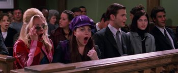 Movie still from “Legally Blonde” (2001), directed by Robert Luketic – A woman in a purple hat is in a courtroom; Close Up shot, Over the shoulder angle