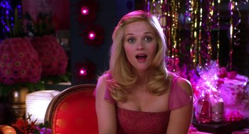 Movie still from “Legally Blonde 2: Red, White & Blonde” (2003), directed by Charles Herman-Wurmfeld – A woman in a pink dress sitting on a red chair; Close Up shot, Over the shoulder angle
