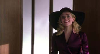 Movie still from “Legally Blonde 2: Red, White & Blonde” (2003), directed by Charles Herman-Wurmfeld – A woman wearing a purple suit and a black hat; Medium shot, Low angle