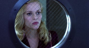 Movie still from “Legally Blonde 2: Red, White & Blonde” (2003), directed by Charles Herman-Wurmfeld – A woman looking into a mirror in front of a fence; Close Up shot, Low angle