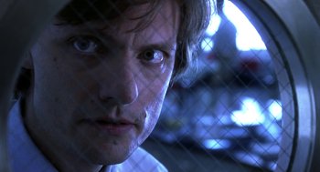 Movie still from “Legally Blonde 2: Red, White & Blonde” (2003), directed by Charles Herman-Wurmfeld – A man's face behind a chain link fence; Close Up shot, Low angle
