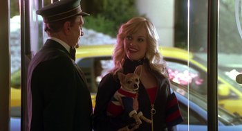 Movie still from “Legally Blonde 2: Red, White & Blonde” (2003), directed by Charles Herman-Wurmfeld – A woman holding a small dog while standing next to a man; Medium shot, Over the shoulder angle