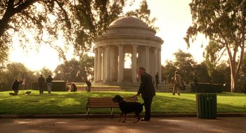 Movie still from “Legally Blonde 2: Red, White & Blonde” (2003), directed by Charles Herman-Wurmfeld – A man in a suit walking a dog on a bench; Extreme Wide shot, Low angle