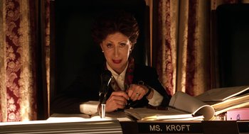 Movie still from “Legally Blonde 2: Red, White & Blonde” (2003), directed by Charles Herman-Wurmfeld – A woman sitting at a desk with a microphone; Close Up shot, Low angle