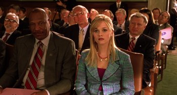 Movie still from “Legally Blonde 2: Red, White & Blonde” (2003), directed by Charles Herman-Wurmfeld – A woman sitting in front of a group of people; Medium shot, High angle