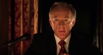 Movie still from “Legally Blonde 2: Red, White & Blonde” (2003), directed by Charles Herman-Wurmfeld – An older man wearing a suit and red tie; Close Up shot, Low angle