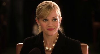 Movie still from “Legally Blonde 2: Red, White & Blonde” (2003), directed by Charles Herman-Wurmfeld – A person wearing a suit and pearl necklace; Close Up shot, Low angle