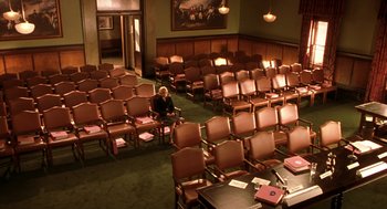 Movie still from “Legally Blonde 2: Red, White & Blonde” (2003), directed by Charles Herman-Wurmfeld – An old woman sitting in a room full of empty chairs; Extreme Wide shot, High angle