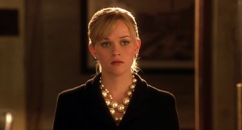 Movie still from “Legally Blonde 2: Red, White & Blonde” (2003), directed by Charles Herman-Wurmfeld – A person wearing a suit and a pearl necklace; Close Up shot, Over the shoulder angle
