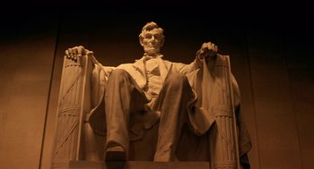Movie still from “Legally Blonde 2: Red, White & Blonde” (2003), directed by Charles Herman-Wurmfeld – A statue of abraham lincoln sitting on top of a bench; Medium shot, Low angle