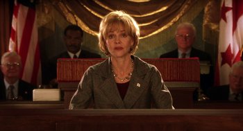 Movie still from “Legally Blonde 2: Red, White & Blonde” (2003), directed by Charles Herman-Wurmfeld – A woman sitting in front of two men in a courtroom; Medium shot, Low angle