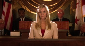 Movie still from “Legally Blonde 2: Red, White & Blonde” (2003), directed by Charles Herman-Wurmfeld – A woman sitting in front of two men in a courtroom; Medium shot, Low angle