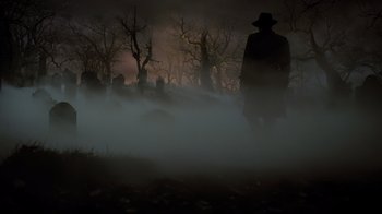 Movie still from “A Series of Unfortunate Events” (2004), directed by Brad Silberling – A man in a black coat and hat standing in the fog; Extreme Wide shot, Low angle