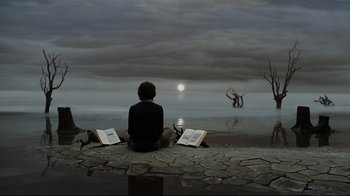 Movie still from “A Series of Unfortunate Events” (2004), directed by Brad Silberling – A person sitting on the ground reading a book by a body of water; Wide shot, High angle