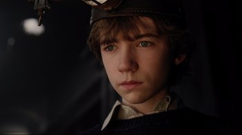 Movie still from “A Series of Unfortunate Events” (2004), directed by Brad Silberling – A young man wearing a hat and a sweater; Close Up shot, High angle