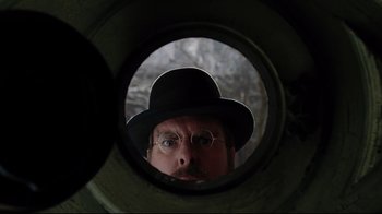 Movie still from “A Series of Unfortunate Events” (2004), directed by Brad Silberling – A man in a hat and glasses looking into a mirror; Close Up shot, Overhead angle