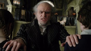 Movie still from “A Series of Unfortunate Events” (2004), directed by Brad Silberling – An old man with white hair wearing a suit and tie; Medium shot, Low angle
