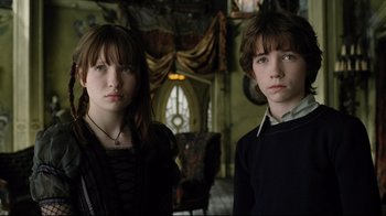 Movie still from “A Series of Unfortunate Events” (2004), directed by Brad Silberling – Two people standing next to each other in a room; Medium shot, Low angle