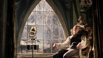 Movie still from “A Series of Unfortunate Events” (2004), directed by Brad Silberling – A man sitting in front of a mirror in front of a window; Medium shot, Low angle