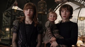 Movie still from “A Series of Unfortunate Events” (2004), directed by Brad Silberling – A group of people standing next to each other in a room; Medium shot, Low angle