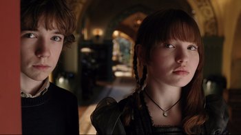 Movie still from “A Series of Unfortunate Events” (2004), directed by Brad Silberling – Two young people standing next to each other in a room; Close Up shot, Low angle