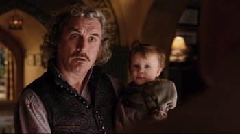 Movie still from “A Series of Unfortunate Events” (2004), directed by Brad Silberling – An older man holding a young girl in his arms; Close Up shot, Over the shoulder angle