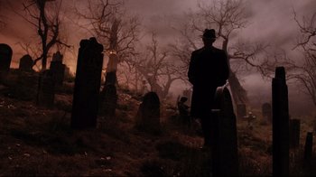 Movie still from “A Series of Unfortunate Events” (2004), directed by Brad Silberling – A man standing in a graveyard; Wide shot, Low angle