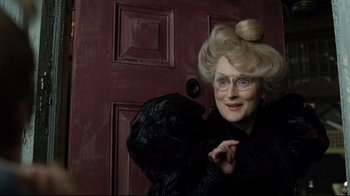 Movie still from “A Series of Unfortunate Events” (2004), directed by Brad Silberling – An older woman wearing a black coat and glasses; Close Up shot, Over the shoulder angle