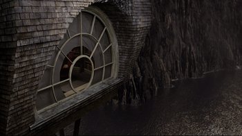 Movie still from “A Series of Unfortunate Events” (2004), directed by Brad Silberling – An image of a window in a building near water; Extreme Wide shot, High angle