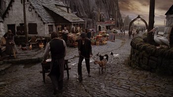 Movie still from “A Series of Unfortunate Events” (2004), directed by Brad Silberling – Two men and two dogs on a cobblestone street; Wide shot, High angle