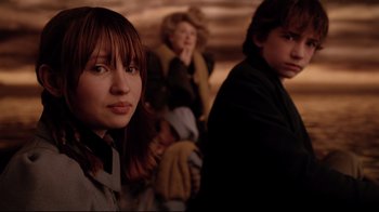 Movie still from “A Series of Unfortunate Events” (2004), directed by Brad Silberling – A group of people standing next to each other in a room; Medium shot, Over the shoulder angle