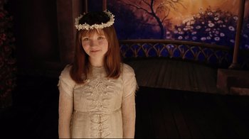 Movie still from “A Series of Unfortunate Events” (2004), directed by Brad Silberling – A young girl in a white dress and a flower crown; Medium shot, High angle