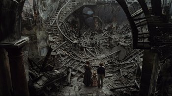 Movie still from “A Series of Unfortunate Events” (2004), directed by Brad Silberling – A group of people standing in the middle of a destroyed building; Extreme Wide shot, High angle