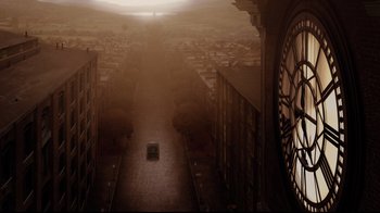 Movie still from “A Series of Unfortunate Events” (2004), directed by Brad Silberling – A car driving down a street with a clock tower in the background; Extreme Wide shot, High angle