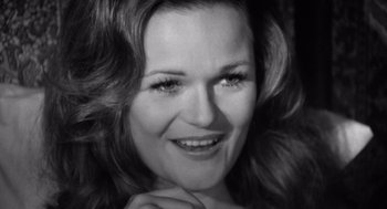 Movie still from “Lenny” (1974), directed by Bob Fosse – Black and white photograph of a woman smiling for the camera; Close Up shot, High angle