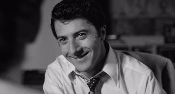 Movie still from “Lenny” (1974), directed by Bob Fosse – Black and white photograph of a man smiling; Close Up shot, High angle