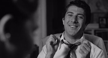 Movie still from “Lenny” (1974), directed by Bob Fosse – A black and white photo of a man adjusting his neck tie; Close Up shot, Low angle