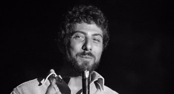 Movie still from “Lenny” (1974), directed by Bob Fosse – Black and white photograph of a man smoking a pipe; Close Up shot, Low angle