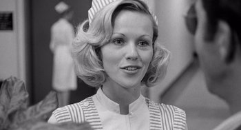 Movie still from “Lenny” (1974), directed by Bob Fosse – Black and white photograph of a woman in a nurse's uniform; Close Up shot, Low angle