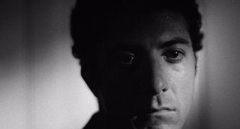 Movie still from “Lenny” (1974), directed by Bob Fosse – A black - and - white photo of a man's face; Close Up shot, Low angle