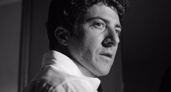 Movie still from “Lenny” (1974), directed by Bob Fosse – Black and white photograph of a man in a white dress shirt; Close Up shot, Low angle